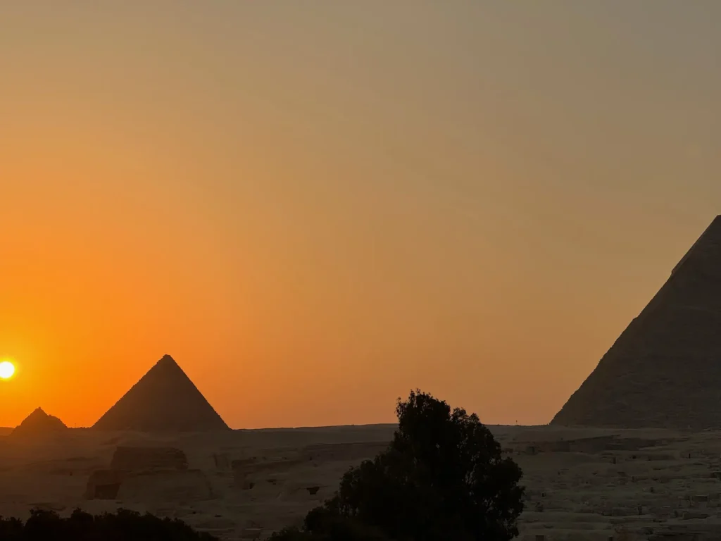 Egitto per nomadi digitali 5 Il sole che cala dietro le piramidi, da una terrazza di Giza. Ottobre 2023.